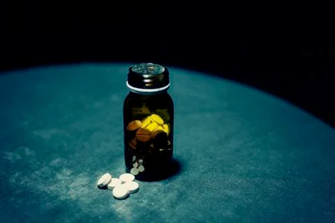 Pills in bottle dramatic Stock Photos