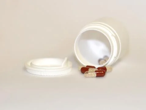 Pills in capsule on grey background Stockfoto's