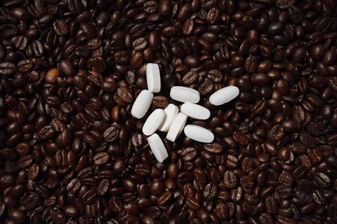 Pills on coffee beans Foto stock