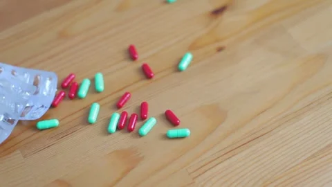 The pills fall from above onto the table. Concept of taking medications for 스톡 동영상 262422154