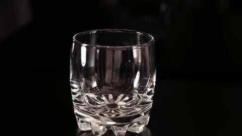 Pills fall into a glass. Black background.. Grey cat walks around Stock Footage 125013867