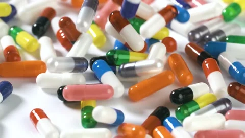 Pills fall onto a white surface in slow motion Stock-Footage 289569901