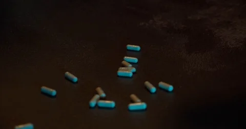 Pills fall on wooden table Stock Footage 126328890