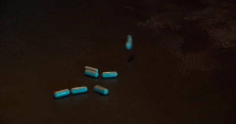 Pills fall on wooden table Stock Footage 126328948