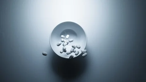 Pills falling in a cup. Slow motion Stock Footage 91827056