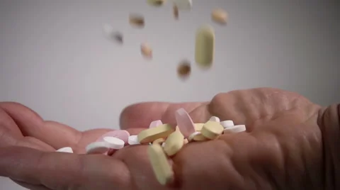 Pills falling into man's hand in slow motion Stock Footage 55346596