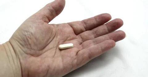 Pills falling into open hand, 4K Stock Footage 78809248
