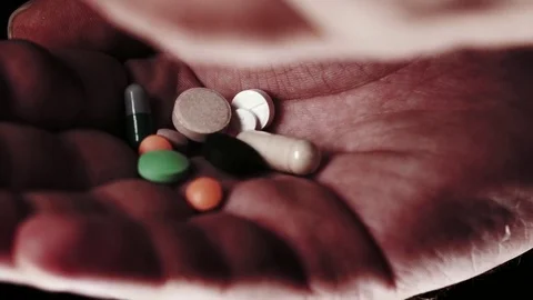 Pills falling in an open palm. Multiple takes. Video stock 82877521
