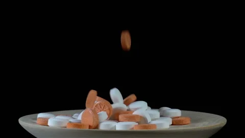 Pills falling in slow motion on black Stock Footage 140618604