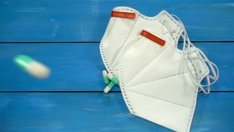 Pills falling in slow motion on surgical masks Stock Footage 140192007