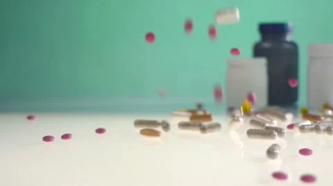 Pills falling on table with medicine cans Video stock 65940217