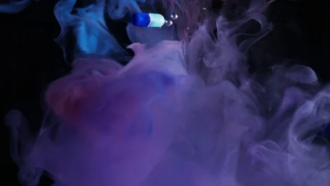 Pills Falling Through Red And Blue Ink 2 Stock Footage 78965655