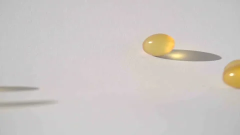 Pills falling on white background top view in slow motion Stock Footage 85625805