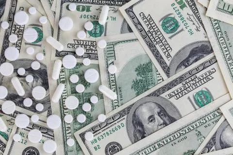 Pills flat background, tablets laying on a us dollar banknotes - view from above Stock Photos