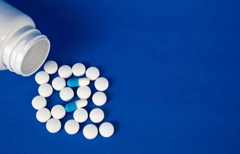 Pills forming circular pattern with bottle, healthcare background Foto stock