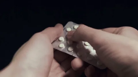 Pills in hand isolated on black background. Man pushes a drug close up shot. POV Stock Footage 69206962