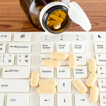 Pills on keyboard computer Stock Photos