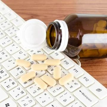 Pills on keyboard computer Stock Photos