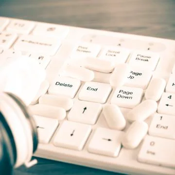 Pills on keyboard computer Stock Photos