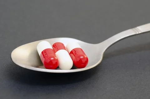 Pills in a kitchen spoon Stock Photos