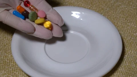 Pills. Medication closeup. Closeup hand puts multicolored pills and capsules on Stock Footage 99439765