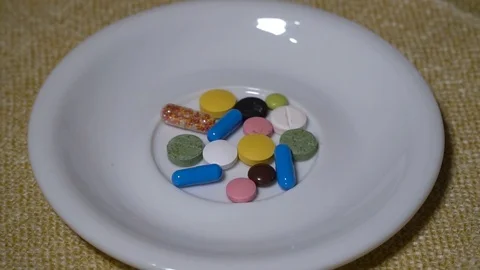 Pills. Medication closeup. A pile of multi-colored tablets lies on a white Stock Footage 99403818