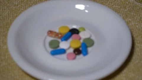 Pills. Medication closeup. A pile of multi-colored tablets lies on a white Video stock 99404394
