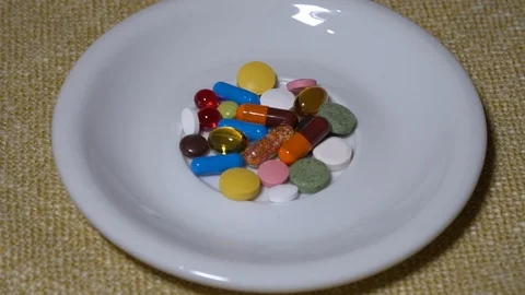 Pills. Medication closeup. A pile of multi-colored tablets lies on a white Stock Footage 99463710