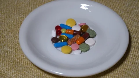 Pills. Medication closeup. A pile of multi-colored tablets lies on a white Stock Footage 99463819