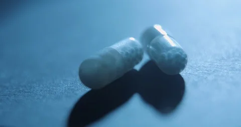 Pills medicine rotating on black background close-up slow motion, studio shot in Stock Footage 126369989