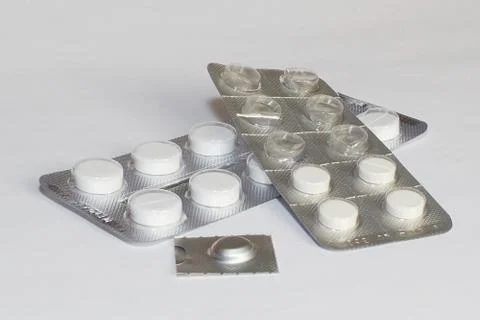 Pills in package lying white table Stock Photos