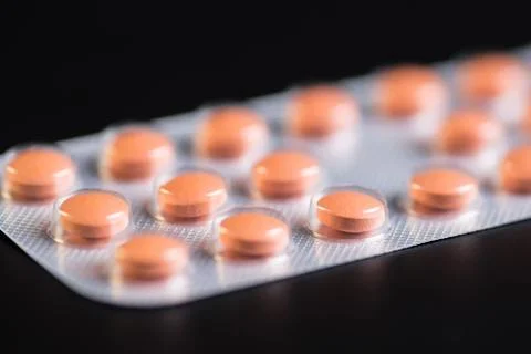 Pills packed in blisters on black background Stock Photos
