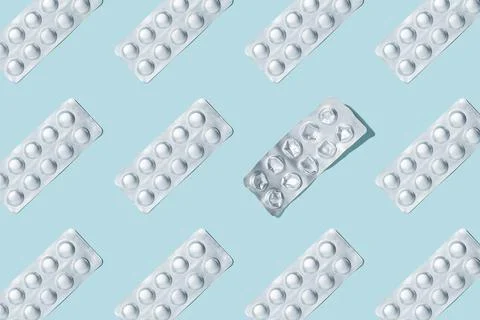 Pills pattern. Composition of medical silver blisters with pills on a blue Stock Photos