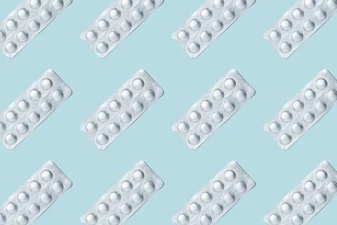 Pills pattern. Composition of medical silver blisters with pills on a blue Fotos de archivo