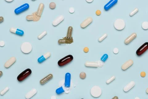 Pills pattern with some capsules open and drug content spilled top view Stock Photos