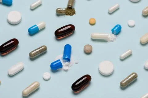 Pills pattern with some capsules open and drug content spilled Stock Photos