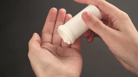 Pills poured into a hand from a jar Stock Footage 85637290