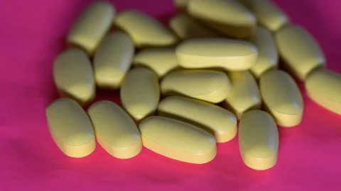 Pills rotate on pink background. Video stock 88474638