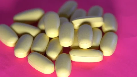 Pills rotate on pink background. Video stock 88614533