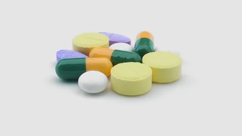 Pills rotating on isolated white Stock Footage