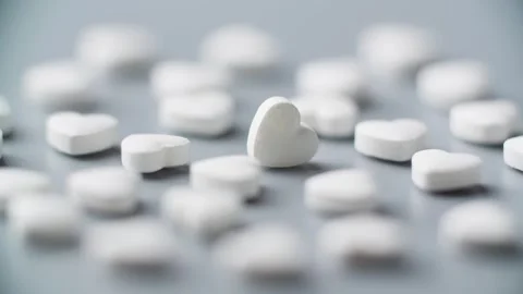 Pills rotating on table. Heart shape. Healthcare concept. Drug medicament Video stock 304825373