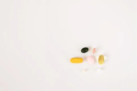 Pills in a row, various forms, white background. Multi-colored pills close-up an Stock Photos