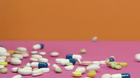 Pills scattered on a pink background. Видео 126555939