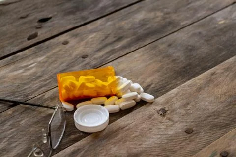 Pills spilled on kitchen table-2 Stock Photos