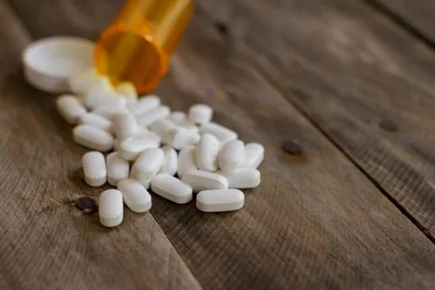 PIlls spilled on kitchen table shallow DOF Stock Photos
