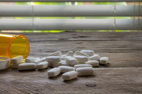 Pills spilled on kitchen table shallow DOF-4 Stock Photos