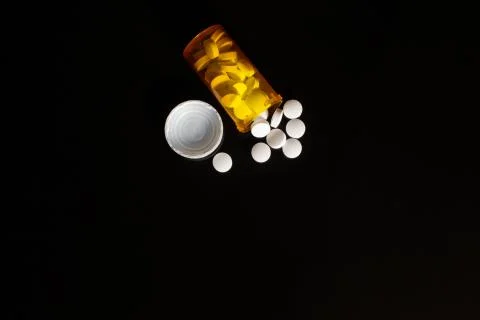 PIlls spilled on table black Stock Photos