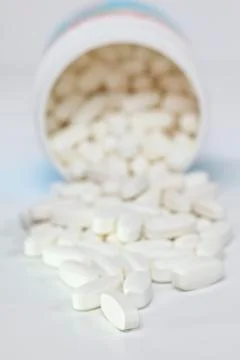 Pills spilling from container Stock Photos