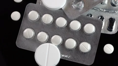 Pills spinning on black table. Close up Видео 104263289