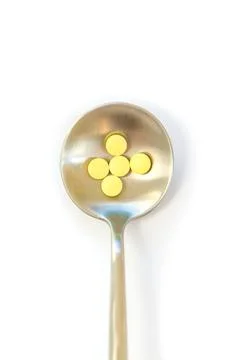 Pills on a spoon isolate on a white background. Selective focus. Stock Photos